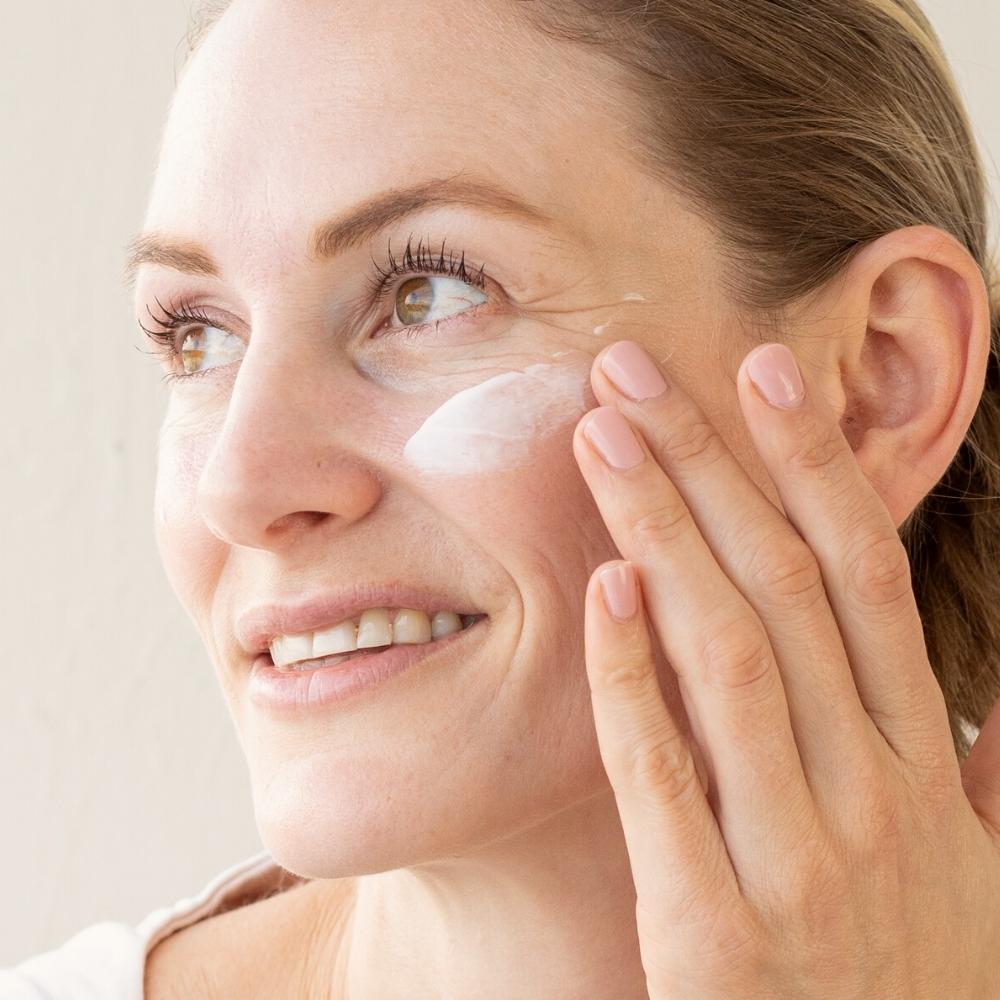 Woman applying facial moisturiser with glyceryl stearate