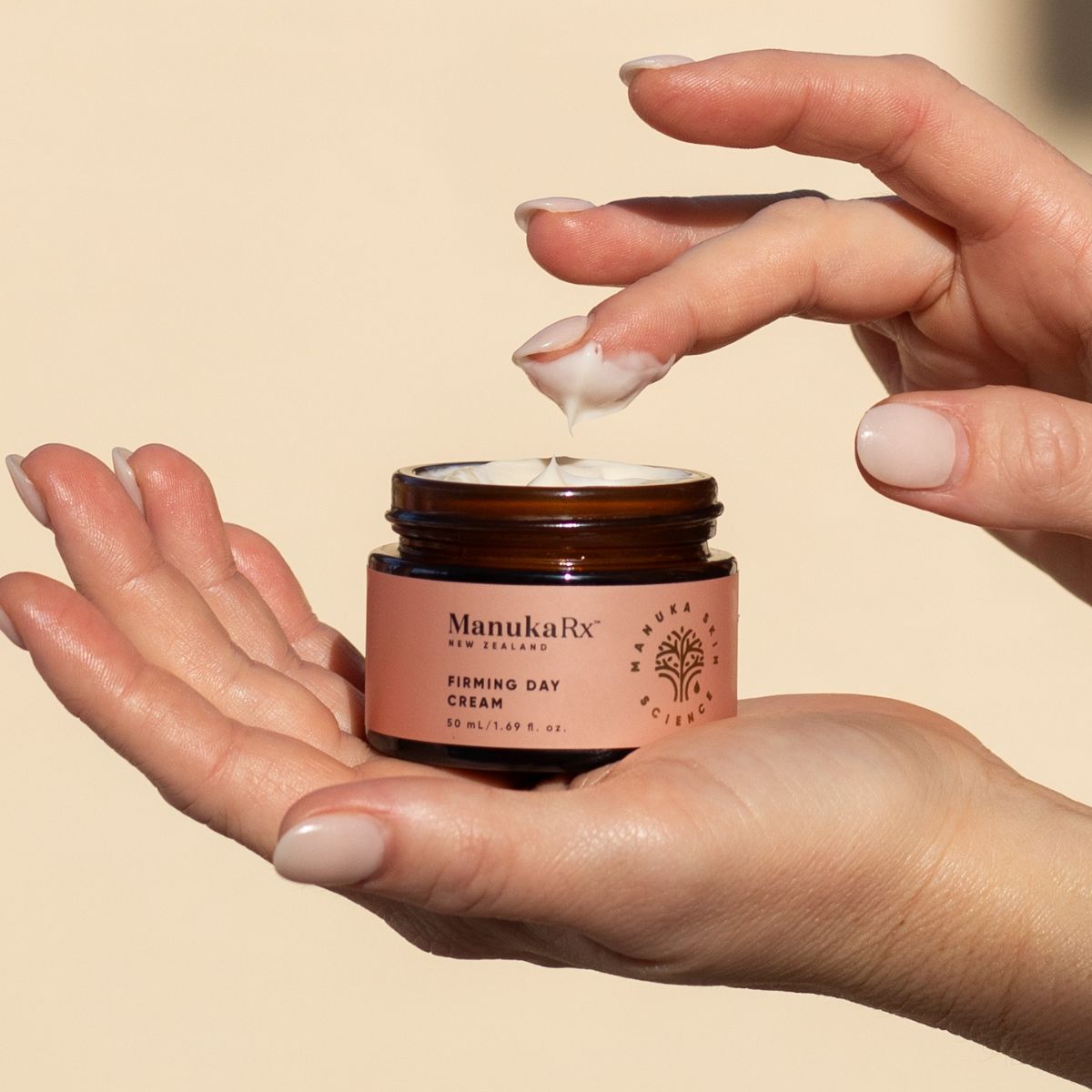 Finger dipping into the Firming Day Cream pot