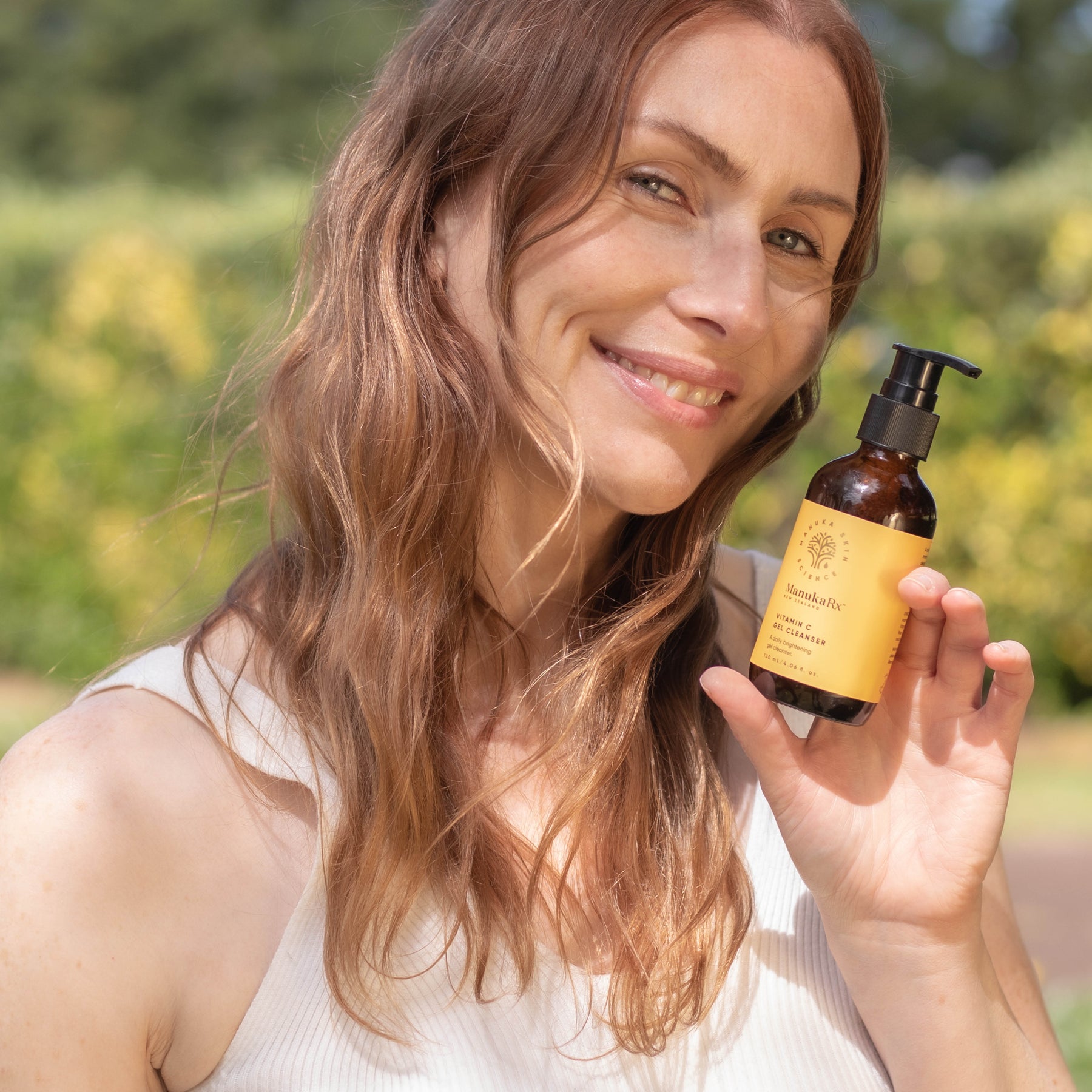 Woman holding bottle of ManukaRx Vitamin C Gel Cleanser