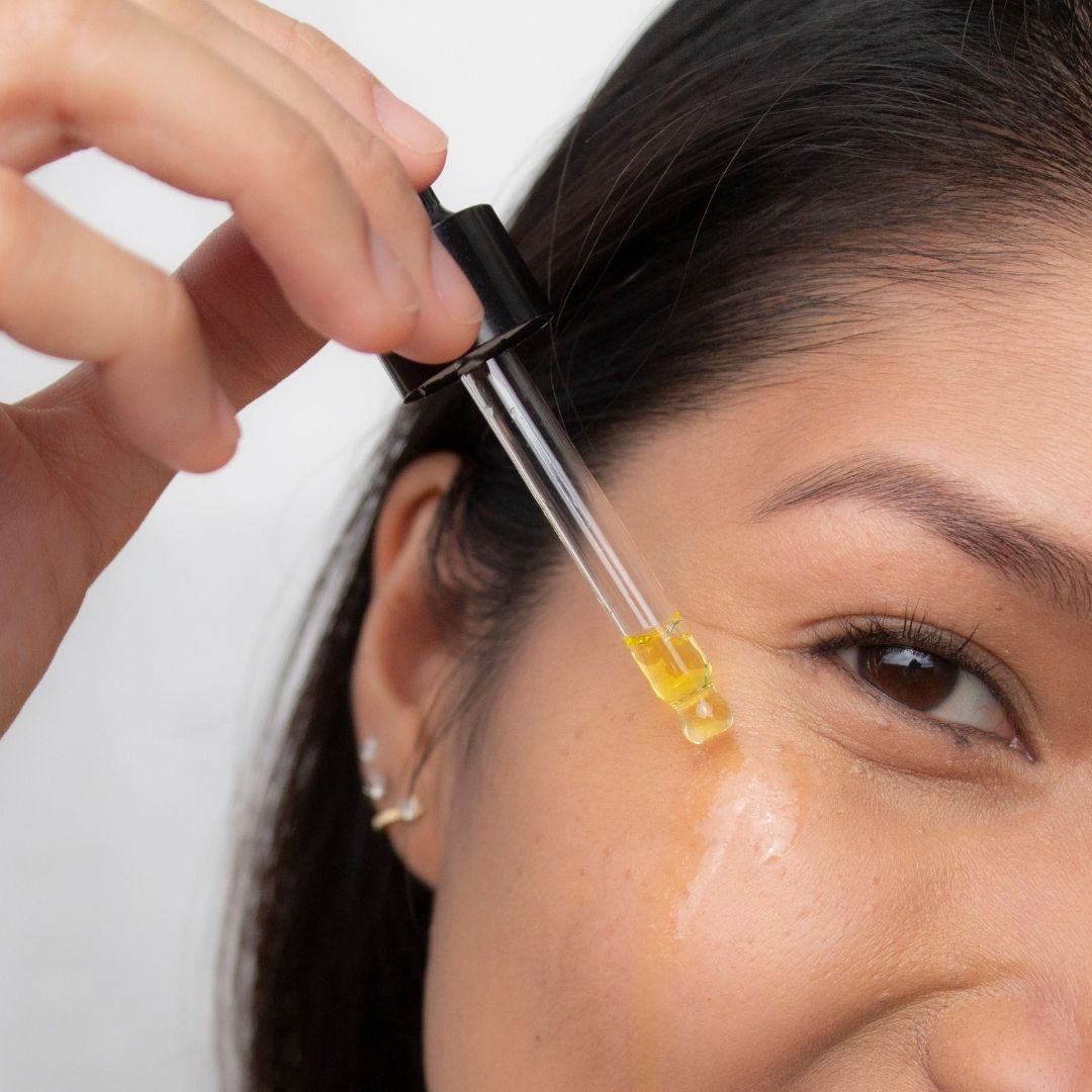 Woman applying ManukaRX Dry Skin Oil with dropper