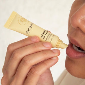 Woman applying ManukaRx Mānuka Lip Balm on her lips